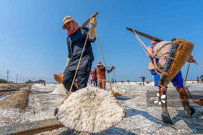 泰国沙没沙空府盐场工人运输盐的场景图片素材