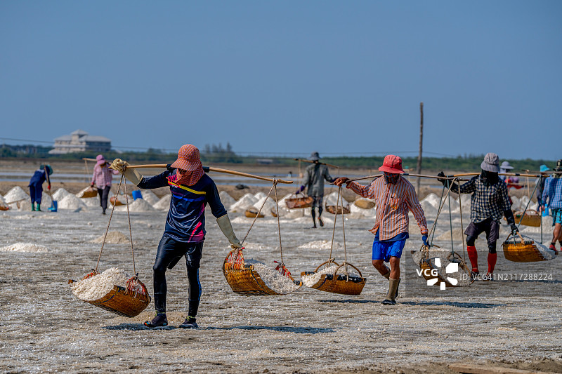 泰国沙没沙空府盐场工人运输盐的场景图片素材