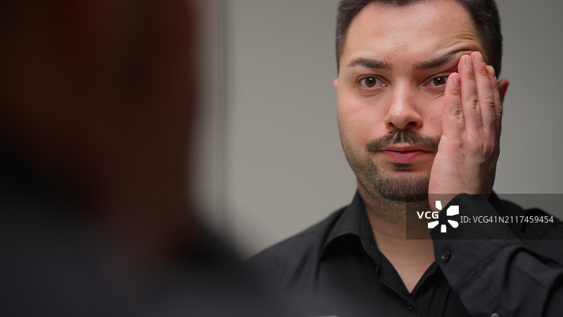 商人感到压力，并在镜子里看着自己图片素材