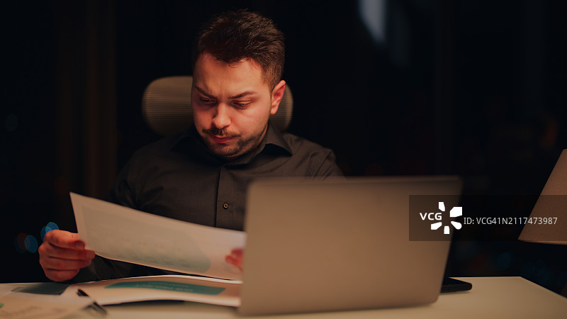 在办公室熬夜工作的压力大的商人图片素材