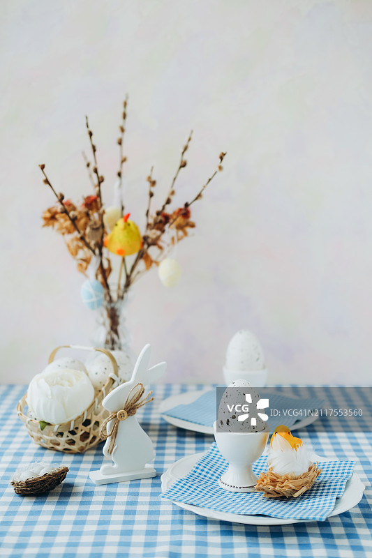 杯子、带鲜花的篮子、装有干燥植物的玻璃花瓶和玩具中的鹌鹑蛋图片素材