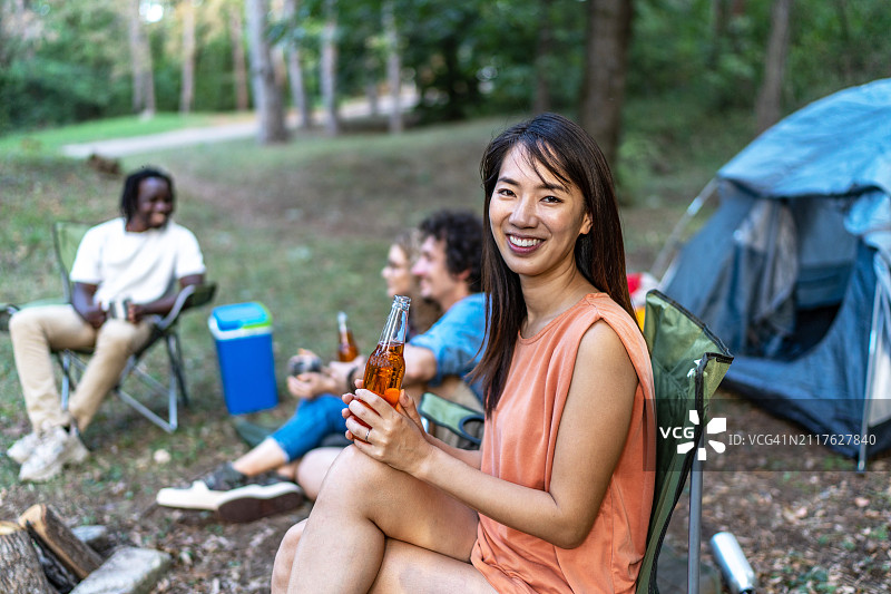 与朋友一起享受野餐的年轻美丽微笑女性肖像图片素材