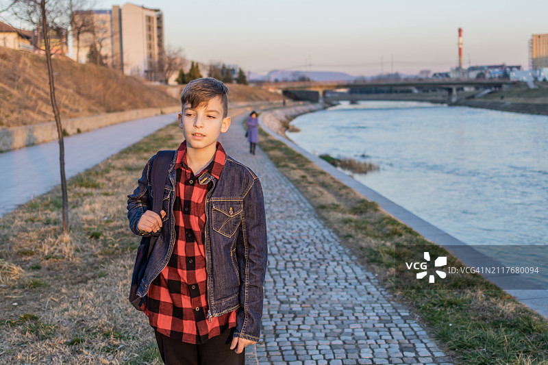 日落时分在河边散步的可爱男孩图片素材