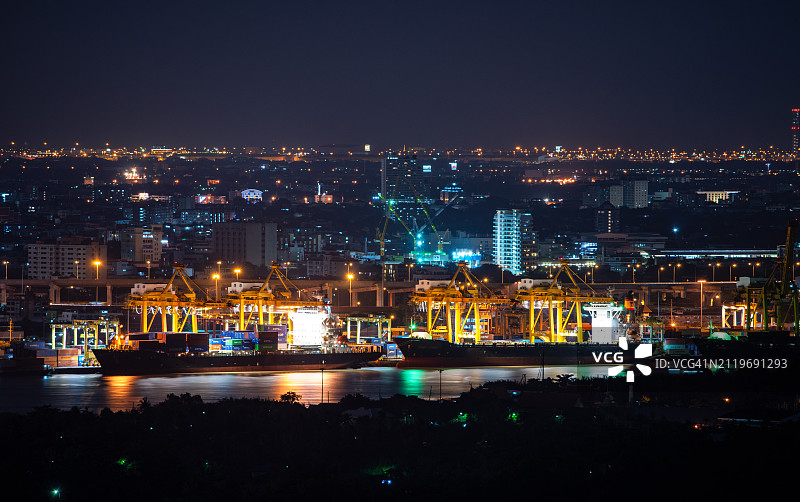 集装箱货轮和货机在日出时于造船厂的物流运输鸟瞰图，起重机桥正在工作，物流进出口和运输业背景图片素材