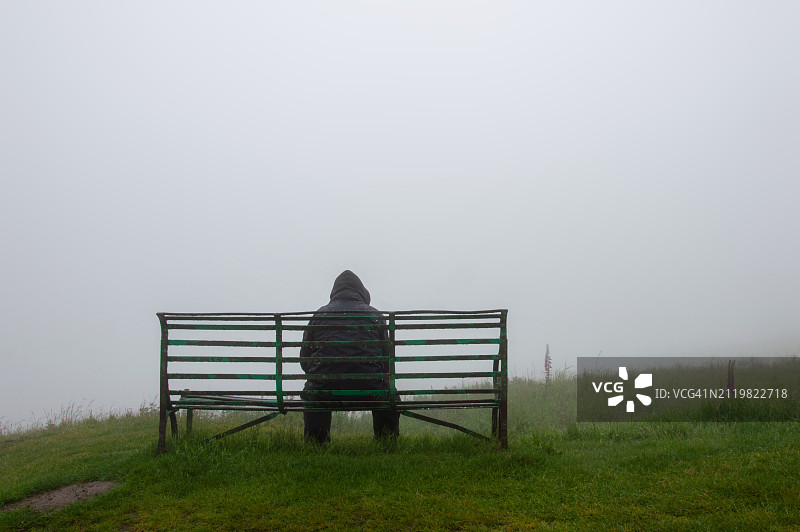 阴雨天乡村长椅上的孤独背影图片素材