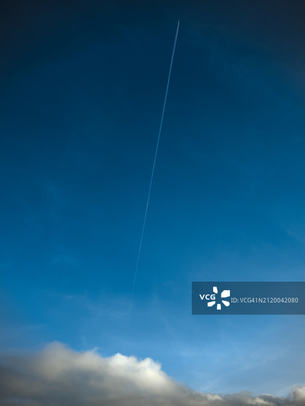 仰视天空中的飞机尾迹图片素材