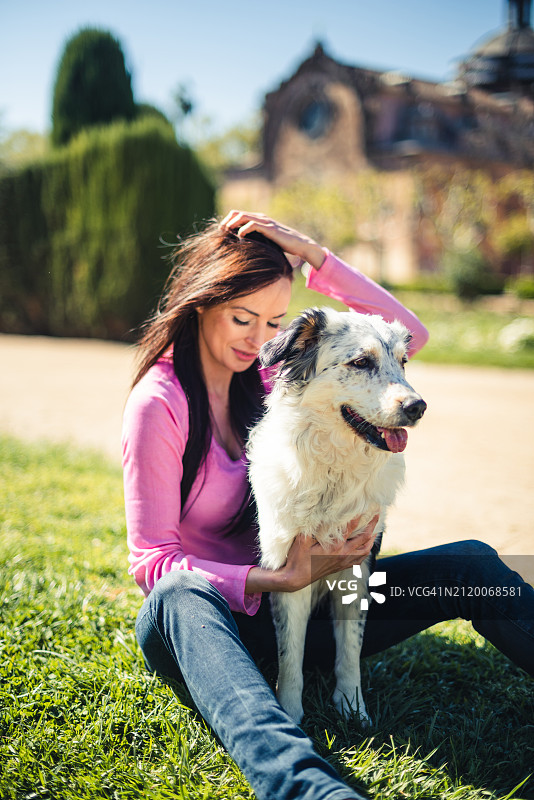 女人和狗坐在公园里图片素材