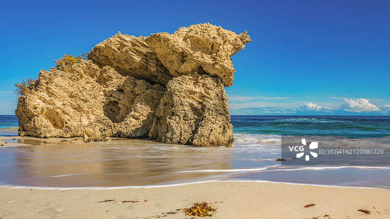 蓝色天空下的海滩岩石景观图片素材
