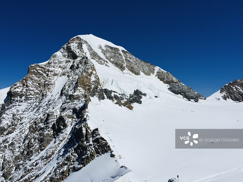 晴朗的蓝天下白雪皑皑的山峰（仰视）图片素材