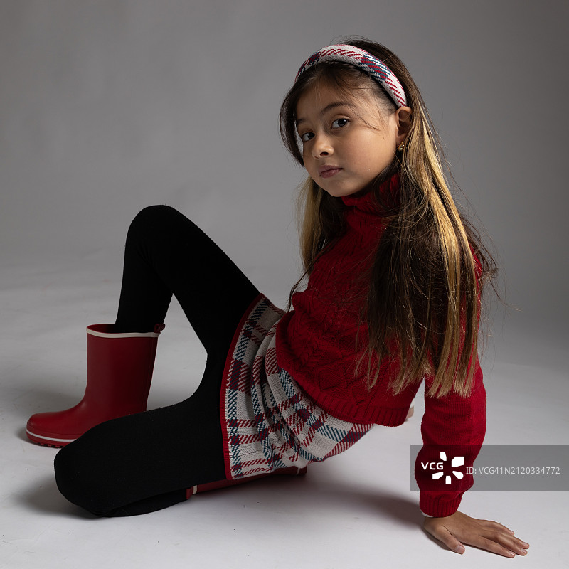 可爱女孩肖像：坐姿，灰色背景图片素材