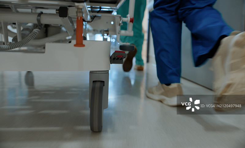医院走廊的紧急医疗场景：医护人员用担架床运送病人图片素材