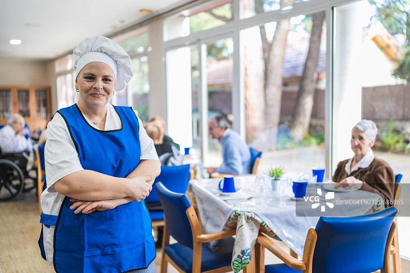 养老院里自信的厨师在餐厅里自豪地摆姿势图片素材