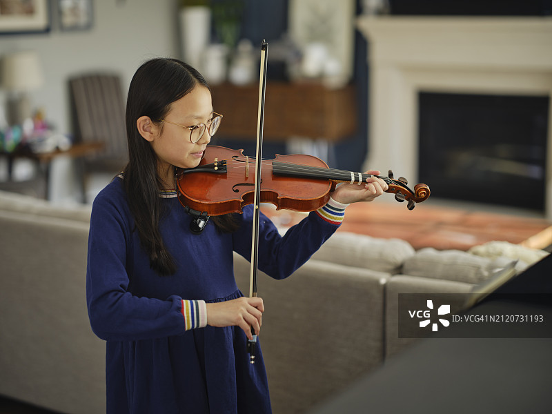 小女孩在家中练习小提琴图片素材