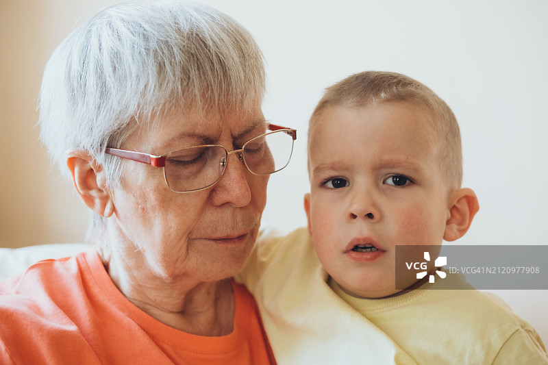 灰发年长妇女和4岁小孙子的肖像图片素材