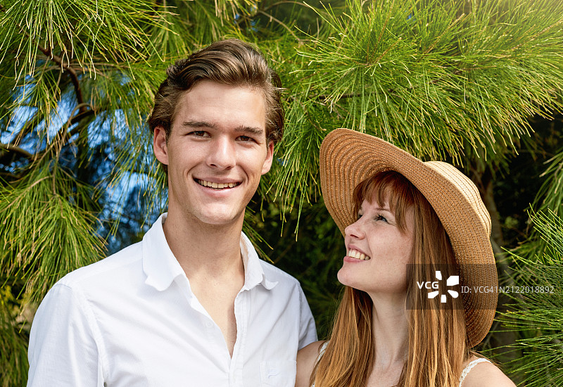 戴太阳帽欣赏着帅气男友的年轻女子图片素材