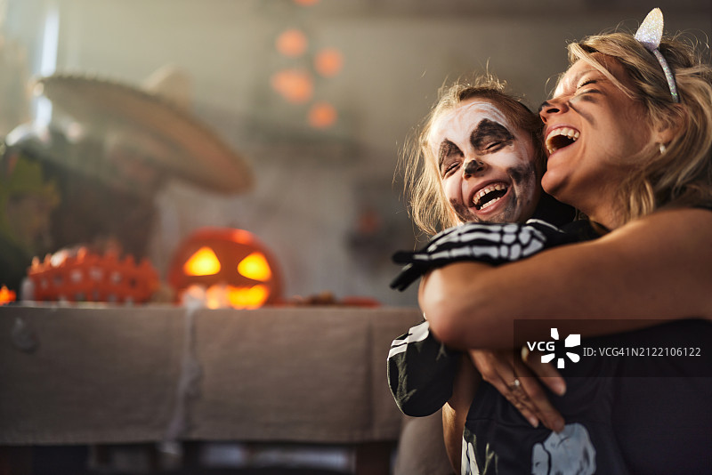 快乐的母亲和女儿在万圣节拥抱在一起图片素材