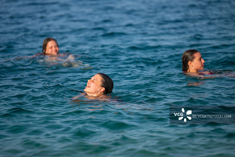 年轻女孩在蓝色大海中嬉戏图片素材