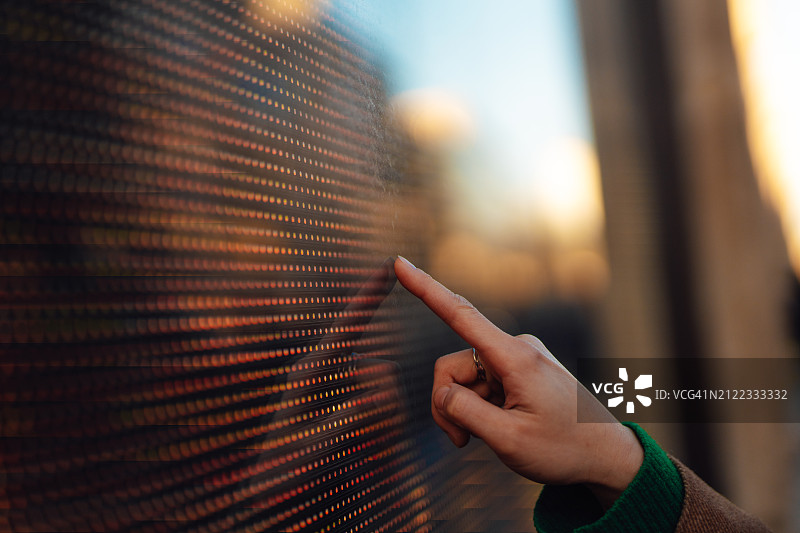 女性手指触摸未来科技互动屏幕特写图片素材