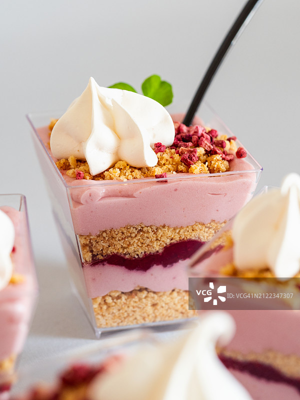 粉色奶油杯甜点特写，含格兰诺拉麦片和浆果奶油图片素材
