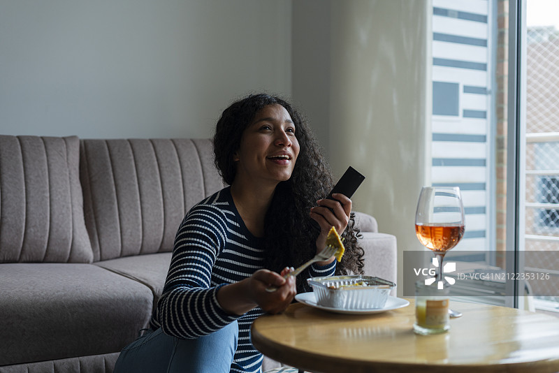 独自在家看电视吃意大利饺子的女人图片素材