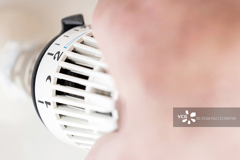 人手调节加热器上的恒温器图片素材