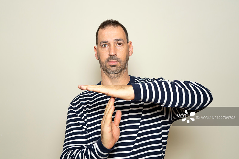 靠墙做手势的男子肖像图片素材