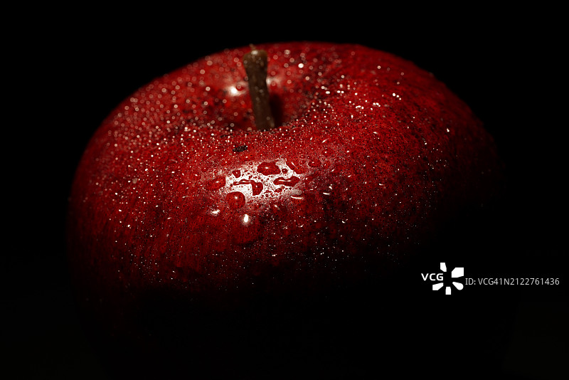 黑色背景下的湿苹果特写图片素材