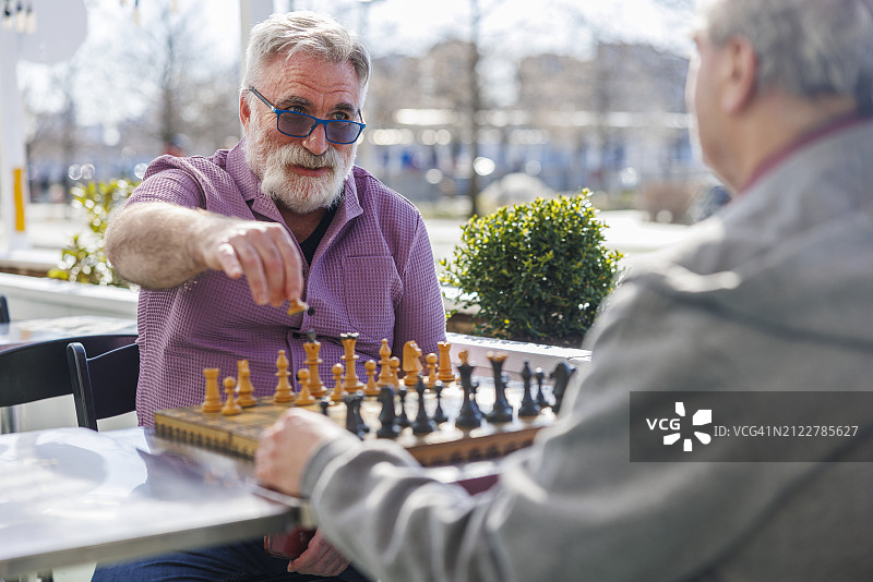 不老爱好：老年胖胡子退休者戴着眼镜在纽约皇后区甘特里广场州立公园户外下棋图片素材