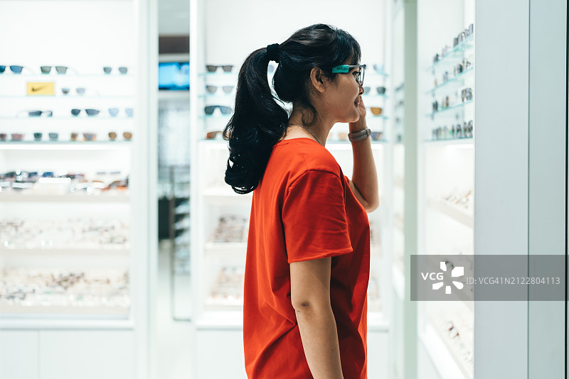 女人在眼镜店购买并试戴眼镜——视力概念图片素材