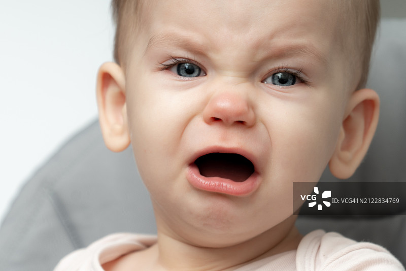 哭泣的可爱男孩特写，白色背景图片素材
