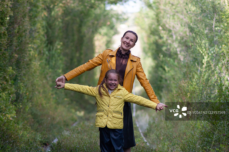 母女在树木隧道中玩耍图片素材