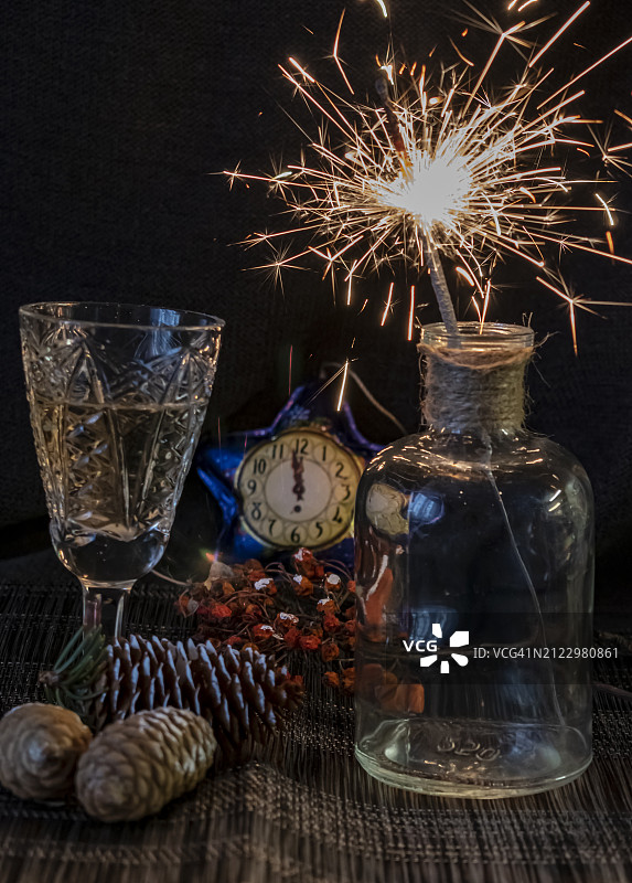 黑色背景下桌子上点燃的蜡烛和饮品特写图片素材