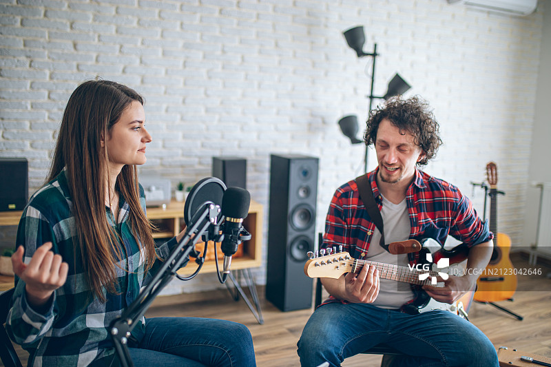 年轻情侣在音乐工作室录制新歌图片素材