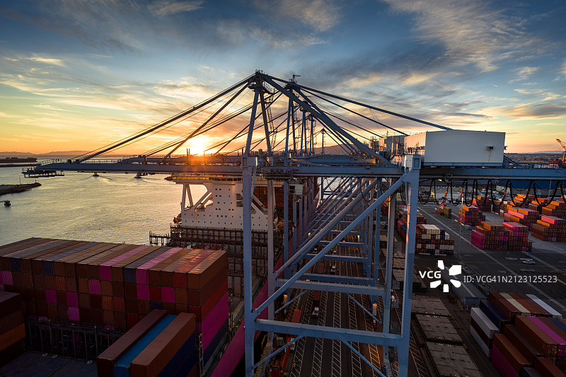 集装箱起重机支架间的夕阳景色图片素材