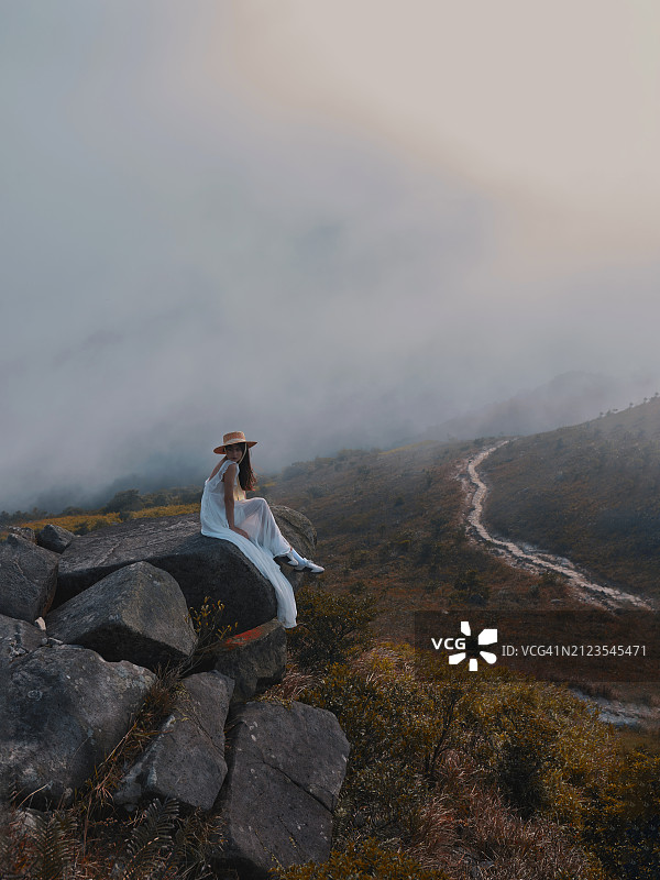 坐在岩石上欣赏天空的女人图片素材