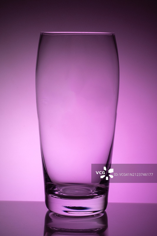 粉色背景下的饮用玻璃杯特写图片素材