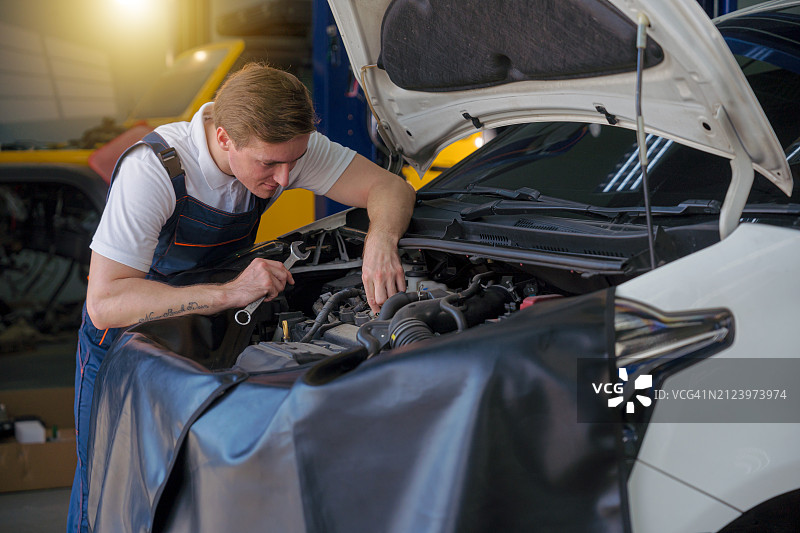 男技工在维修站检查汽车发动机图片素材