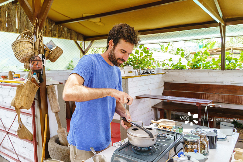 男农民用厨房罐烘烤咖啡豆图片素材