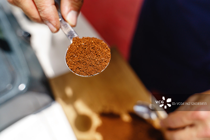 农民手持棕色咖啡勺特写图片素材
