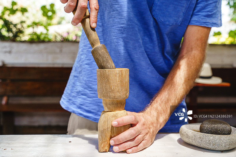 无法辨认的农民在传统厨房里手工研磨咖啡豆的特写图片素材