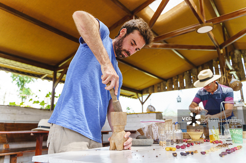 哥伦比亚农民在传统厨房里手工研磨咖啡豆的特写图片素材