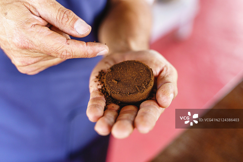农民手持咖啡渣的特写镜头图片素材