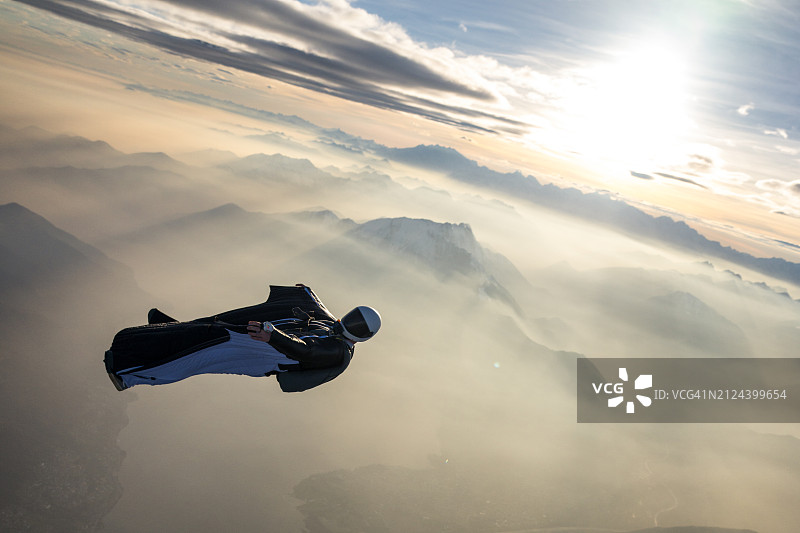 翼装飞行员翱翔于山景之上图片素材