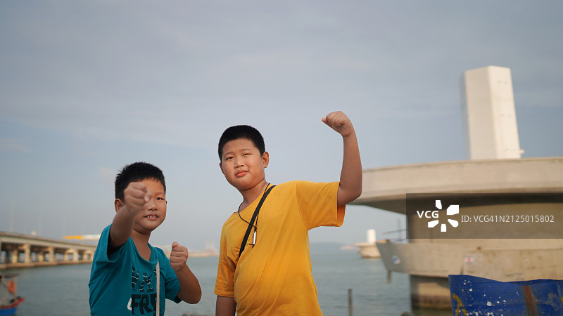 准备战斗的亚洲男孩展示肌肉图片素材