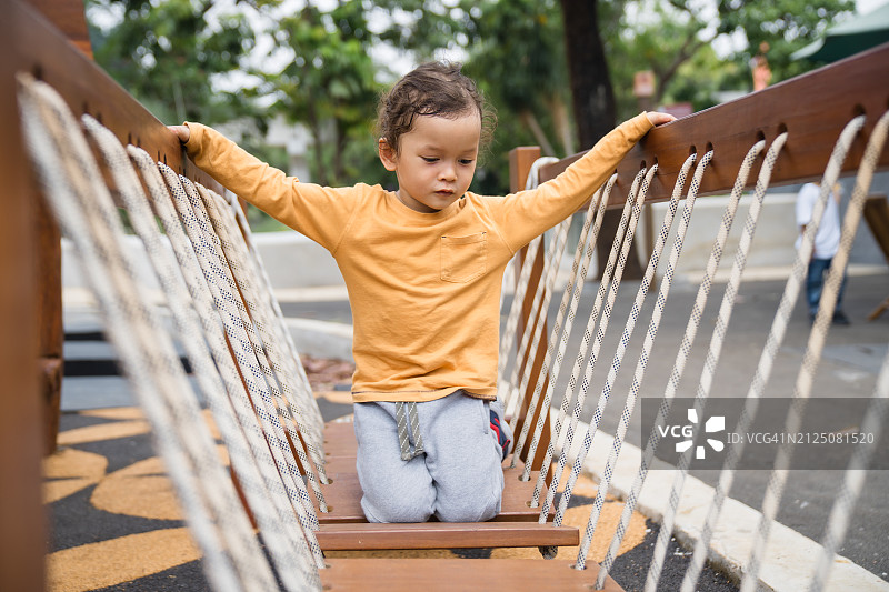 小男孩试图攀爬儿童乐园图片素材