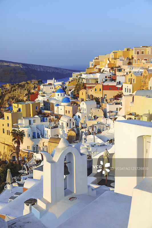 圣托里尼岛伊亚的标志性蓝色圆顶教堂和老钟楼的迷人夏日风光图片素材