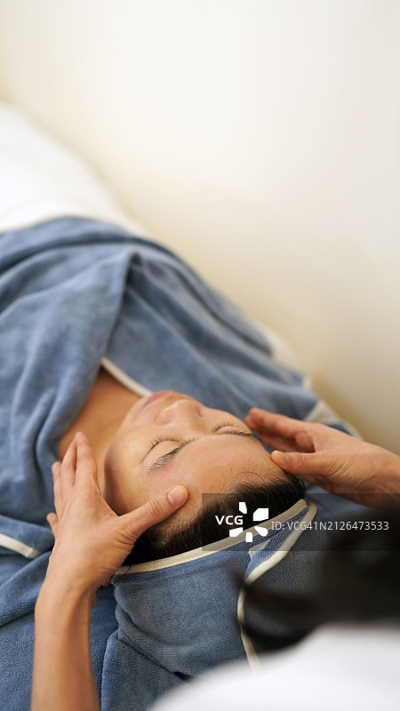 亚洲中年妇女在美容院接受面部护理图片素材