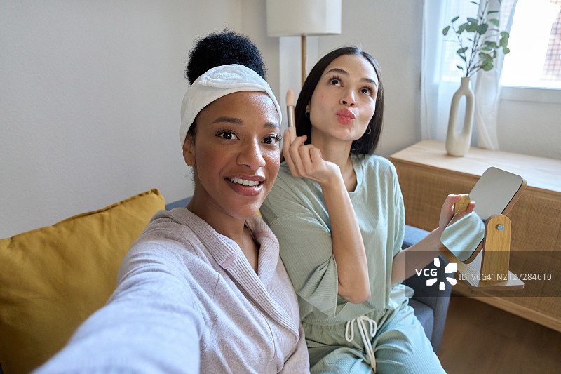多民族朋友在家化妆，一起趣味自拍图片素材