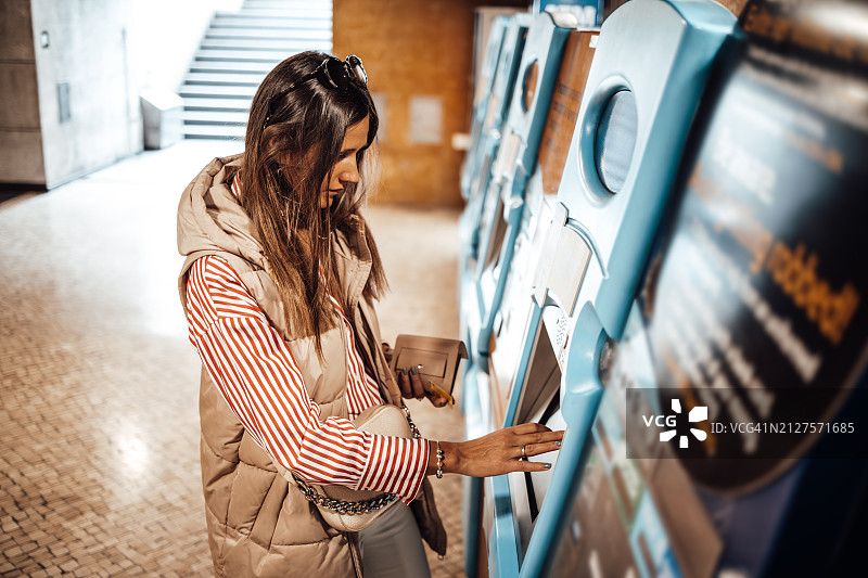 年轻女人在街上使用ATM机图片素材