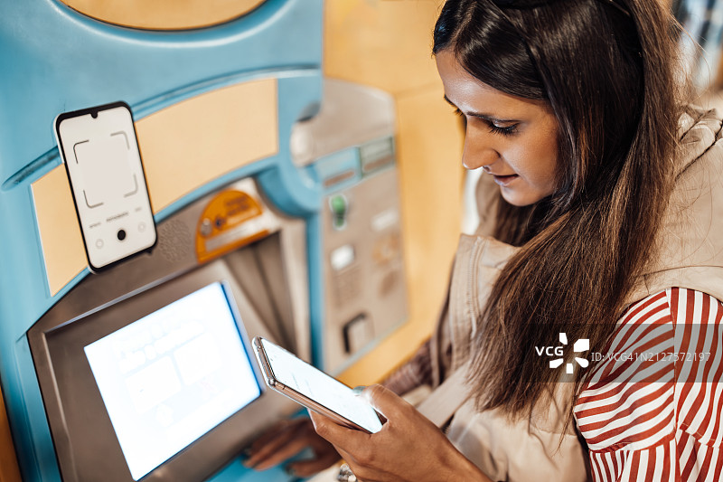 年轻女人在街上使用ATM机图片素材